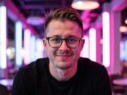 Outdoor portrait of Dr Connor Robertson smiling brightly in nightlight