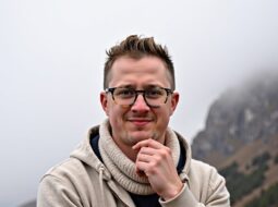 Outdoor portrait of Dr Connor Robertson with greenery background