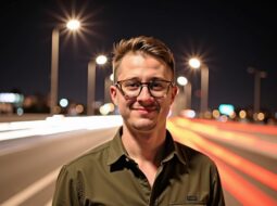 Nightlight outdoor portrait of Dr Connor Robertson smiling naturally