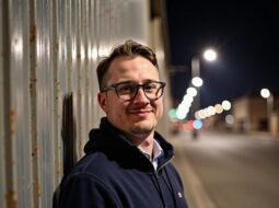 Outdoor headshot of Dr Connor Robertson with blurred nature behind